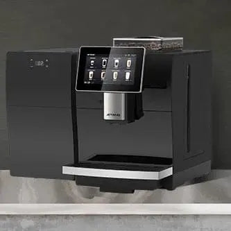 Black coffee machine with digital display on a gray countertop against a dark wall. - Sip N Smile