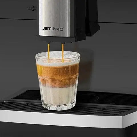 Coffee machine pouring a layered coffee drink into a glass with 'JETINNO' branding. - Sip N Smile